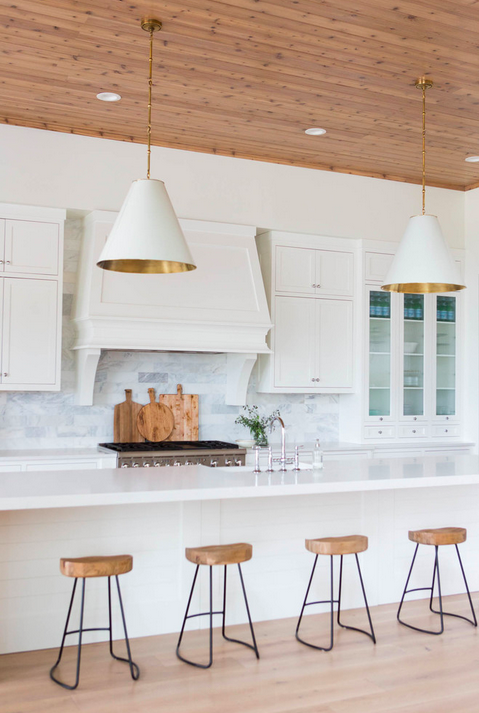 Gorgeous kitchen by Ashley Winn Design with wood paneled ceiling, tile backsplash, and brass-lined fixtures. 