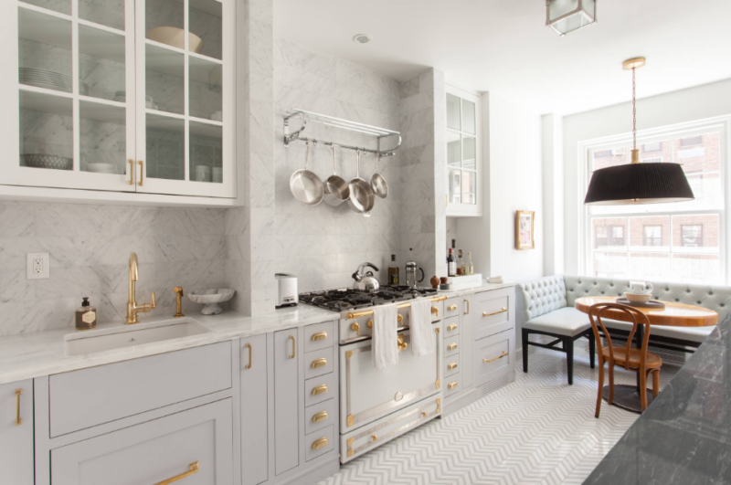 Gorgeous kitchen with herringbone floors, gold fixtures and gray cabinetry.