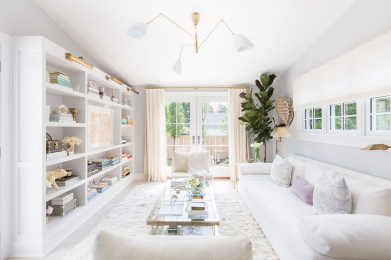 A dreamy cape cod style home designed by Raquel Garcia. White interiors, brass and lucite details, open floor plan, and shiplap.