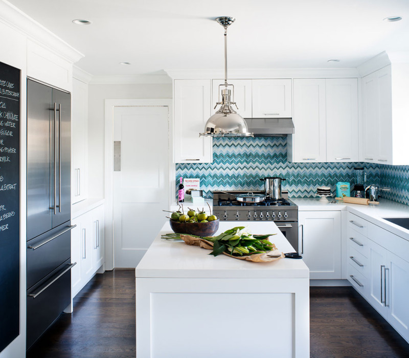 white kitchen with striking blue chevron backsplash and chalkboard wall by Jute Interior Design 