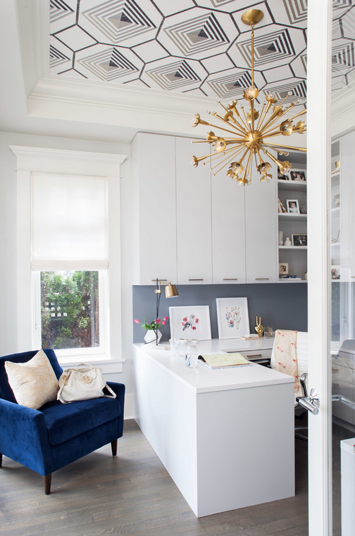 Amazing home office with graphic ceiling and gold accents and navy chair. 