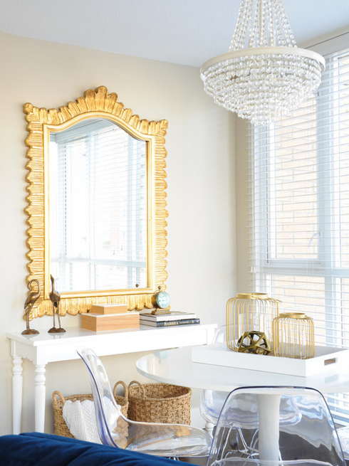 A perfect dining spot--lucite chairs, lovely chandelier, gold accents.  