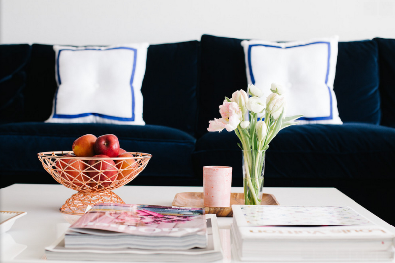 Love this navy velvet sofa, coffee table styling, and polka dot art.  From the apartment tour of Jeanne Chan of Shop Sweet Things