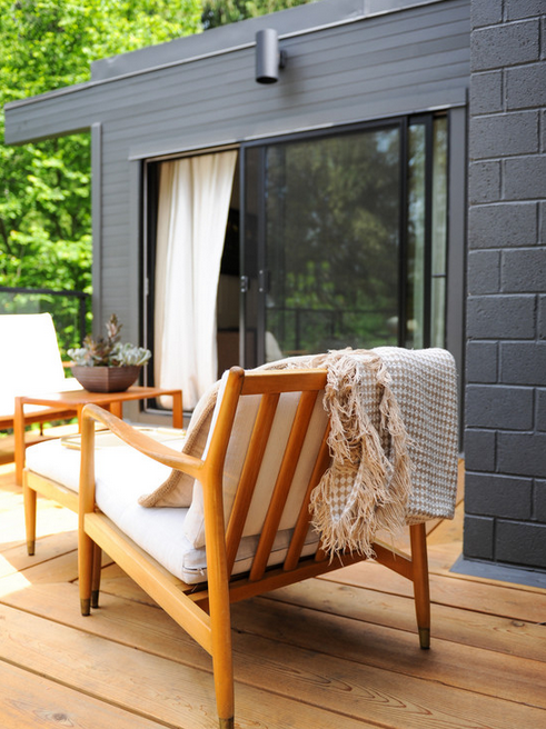 Black exterior brick never looked so good as it does paired with this wood patio set. 