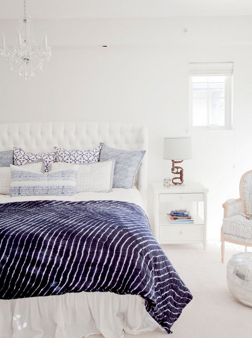 Beautiful white bedroom with tufted headboard and navy blue accents. 