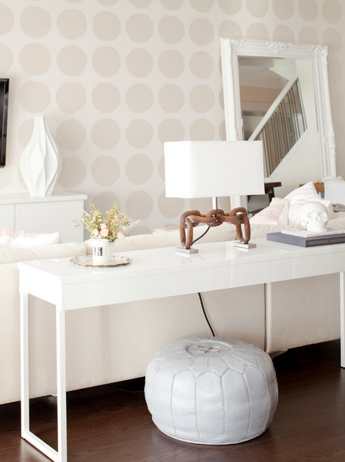 Subtle polka-dotted walls and serene white palette.