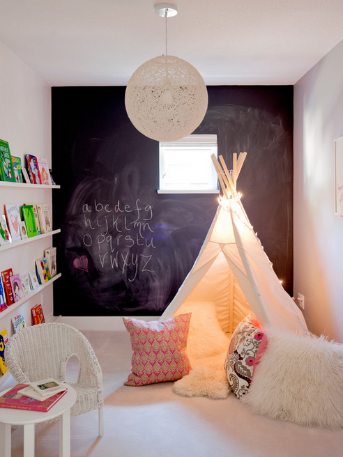 Such a neat kid's space with book ledges lining the wall, a tent with twinkle lights, and a giant chalkboard wall. 