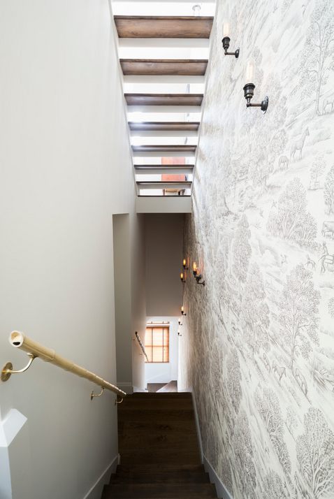 Stunning stairway with toile wallpaper, Edison bulbs, bamboo railings and skylights to boot. 