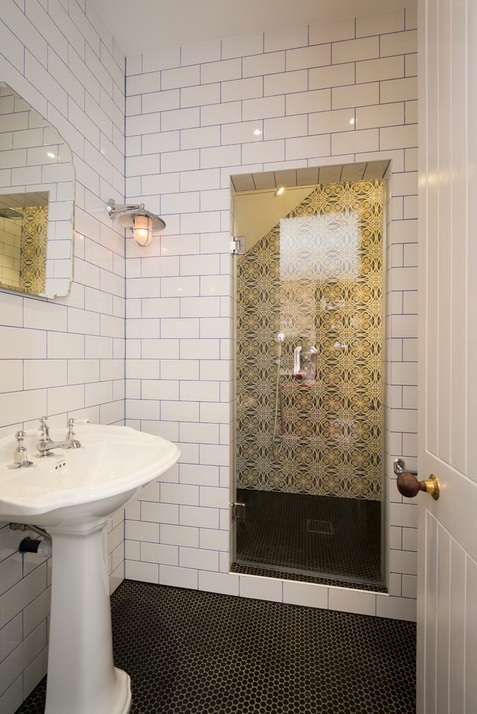 Beautiful bath with white subway tiling, Edison bulbs and a pedestal sink. 