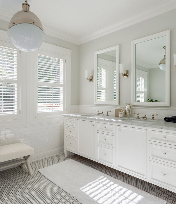 Beautiful white bathroom with a bold light fixture. 