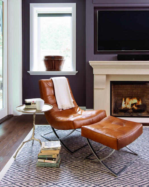 leather reading chair, dark walls and patterned rug make this space by Meghan Carter Design Inc. super inviting. 