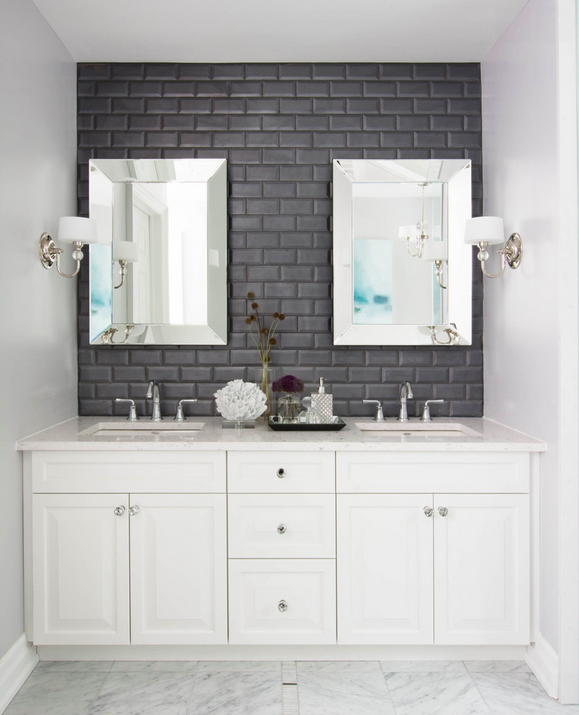 bath with grey subway tiling, dual vanity and marble tile floors. 