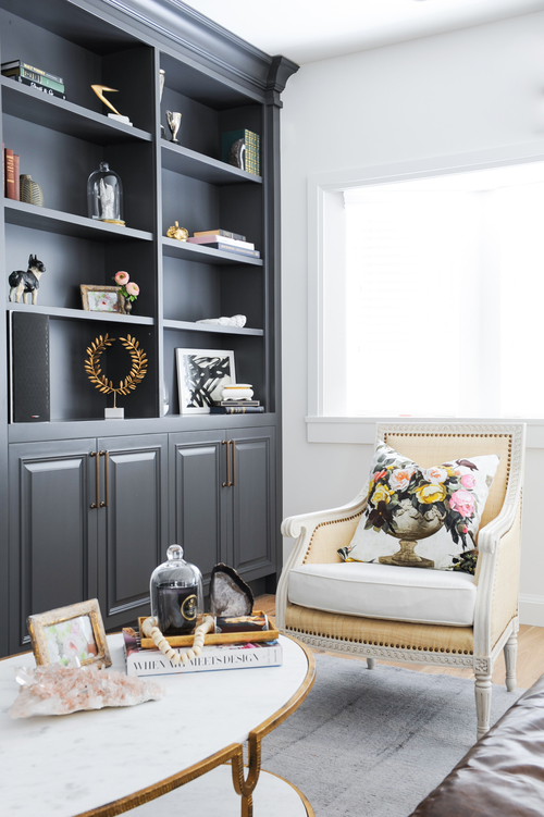 Beautifully styled built-in bookshelves and an elegant accent chair.