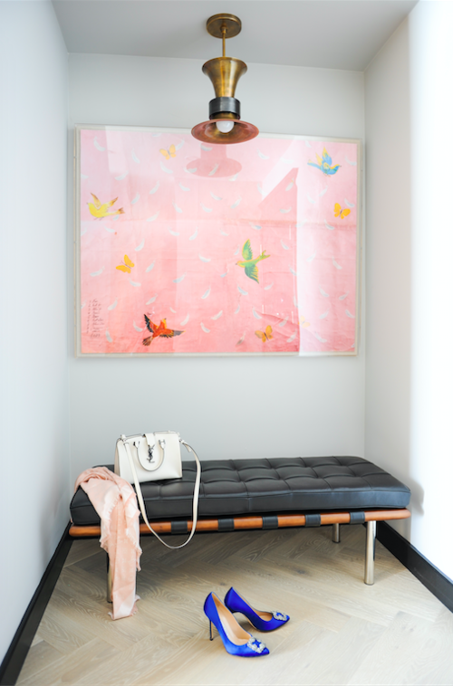 Perfectly sophisticated yet simple entryway with black, leather bench, whimsical pink artwork, and amazing (it must be vintage!) light fixture. 
